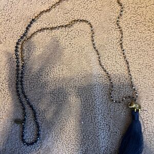 Beaded long necklace with blue tassel and elephant accent.